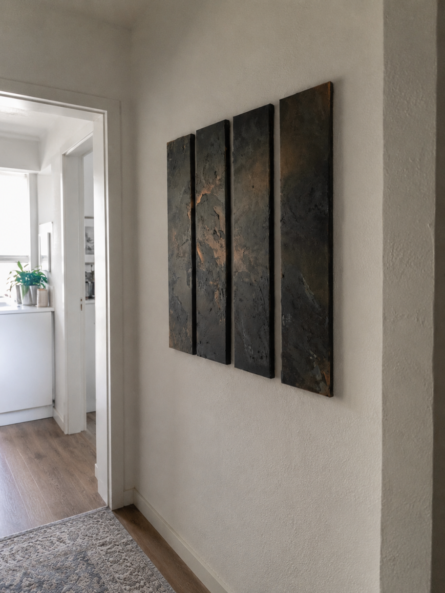 Abstrakte Wandkunst Drei moderne Wandtafeln in dunklen Tönen an einer hellen Wand in einem Flur.