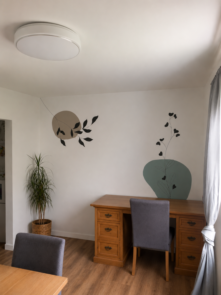 Wandgemälde Helle Büroecke mit einem Tisch, einem Stuhl und dekorativen Wandmotiven.